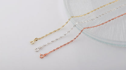A close-up image of 3  Singapore chain necklaces in gold silver and rose on white background