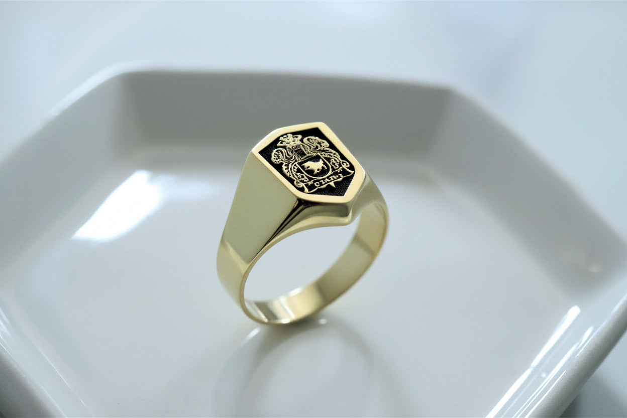 Gold ring with a hexagonal design on a white dish