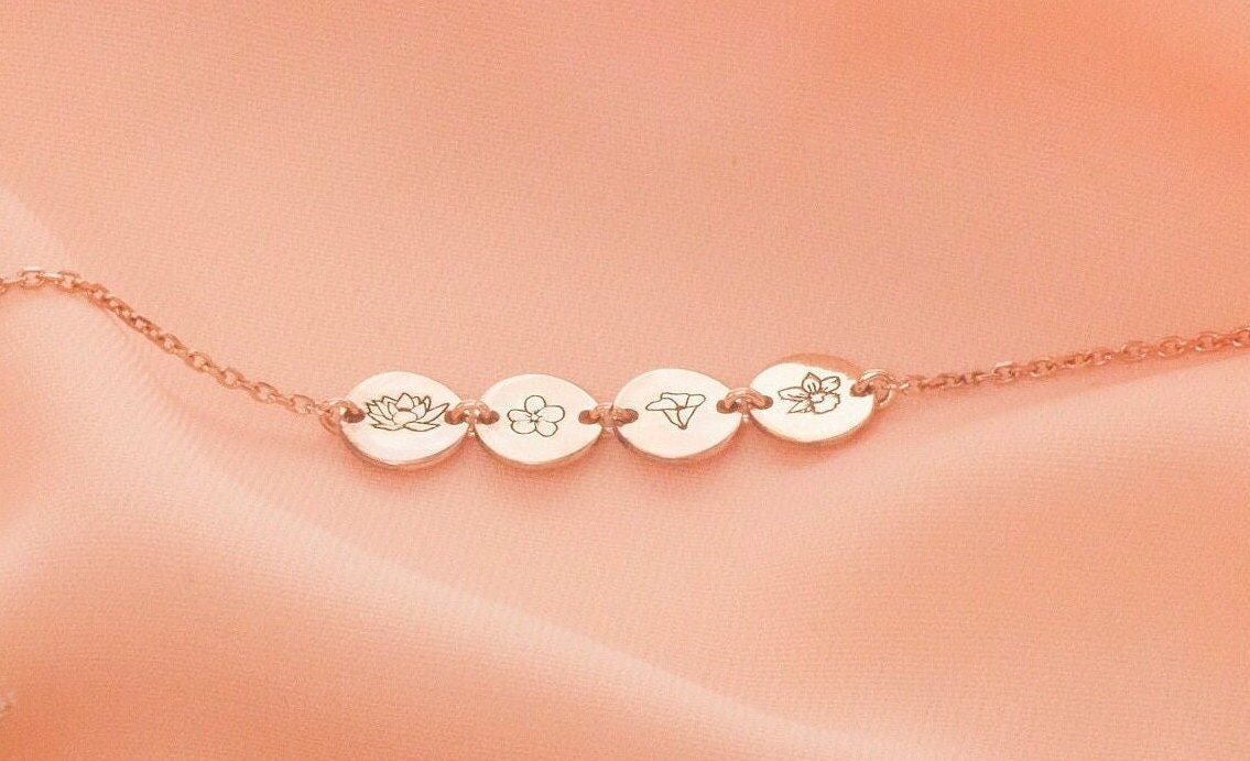 Rose gold bracelet with engraved discs on a peach background