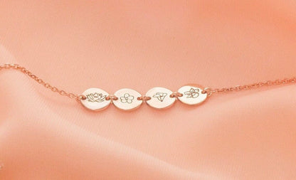 Rose gold bracelet with engraved discs on a peach background