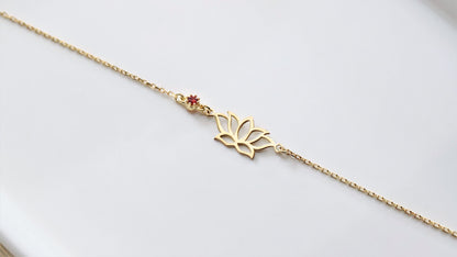 a dainty gold bracelet with a lotus flower design on white background.