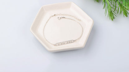 A sterling silver bar bracelet with Roman numerals engraved on it
