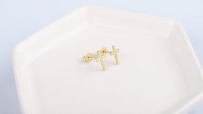 Gold cross-shaped earrings on a white background
