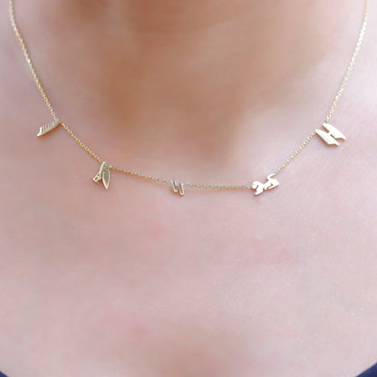 A sterling silver necklace with hieroglyphic characters customized on a person's neck.