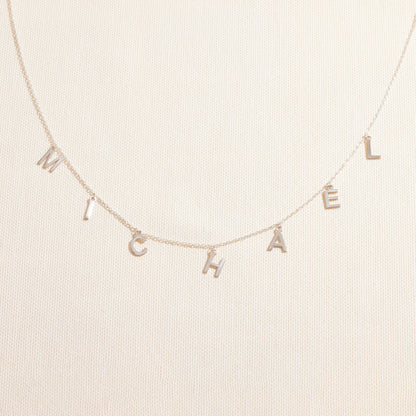 Necklace with 'MICHAEL' letters on a beige background