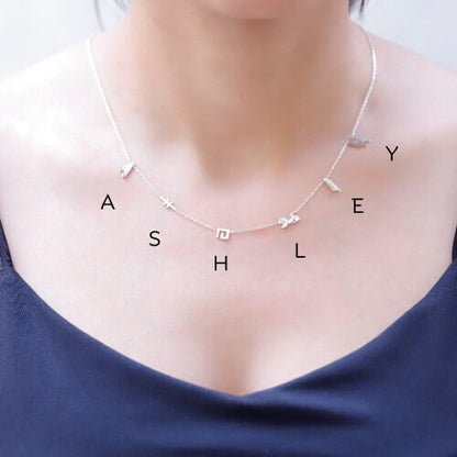 A sterling silver necklace with hieroglyphic characters customized on a person's neck.