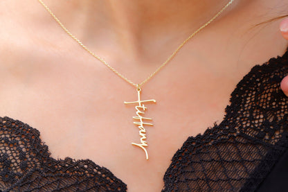 A close-up image of a woman wearing a personalized cross name necklace with the word 'Faith' inscribed on a gold faith cross pendant.