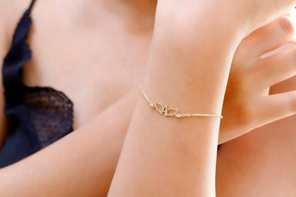 A close-up image of a person wearing a dainty silver bracelet with angel wing details on their wrist.