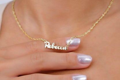 Gold necklace with 'Rebecca' pendant on a hand