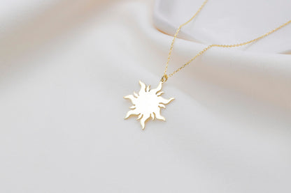 a dainty 14K gold sun necklace with a delicate chain, displayed on a white background