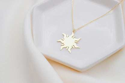 a dainty 14K gold sun necklace with a delicate chain, displayed on a white background