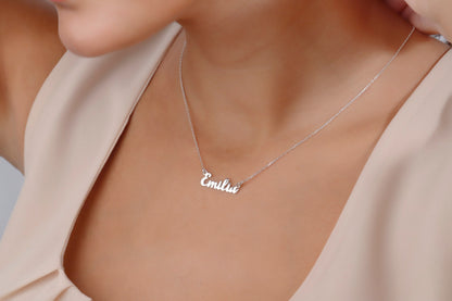 Necklace with 'Emilia' pendant on a person wearing a beige top