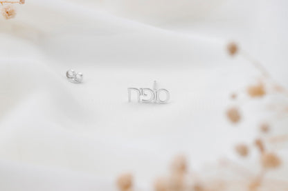 a silver earrings written in Hebrew on a white background