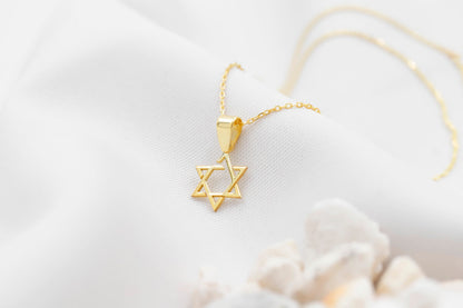 Gold necklace with a Star of David pendant on a light background