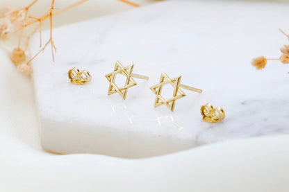Close-up image of a person wearing a gold-filled David Star earring.