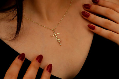 Gold necklace with 'Faith' pendant on a person's neck, with hands touching the necklace.