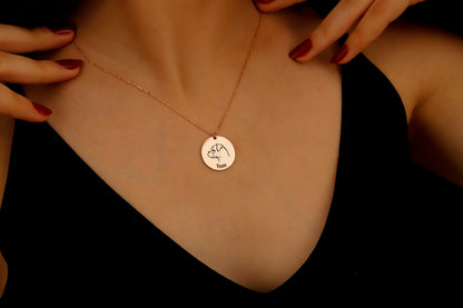 Rose gold necklace with a round pendant on a dark background