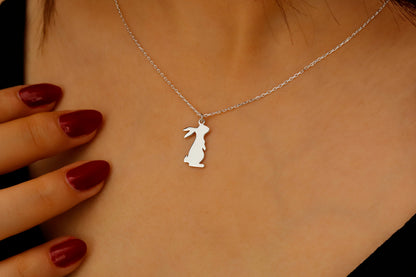 Silver necklace with a rabbit pendant on a person's neck