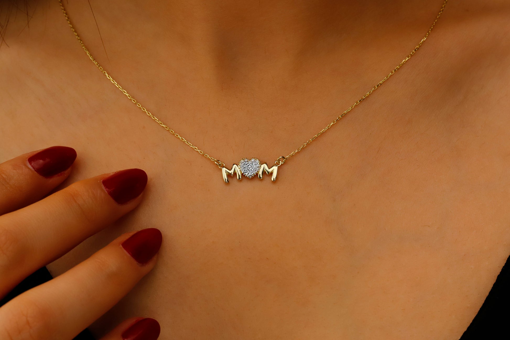 Gold necklace with a small pendant on a person's neck