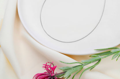 A close-up image of s box chain necklace in silver, displayed on a white background.
