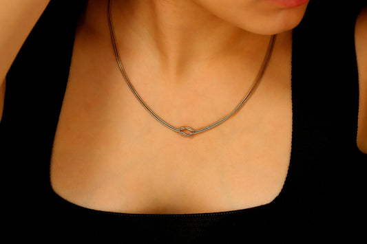 a gold snake chain necklaces on a model