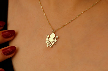 Gold octopus necklace on a person's neck with a blurred background