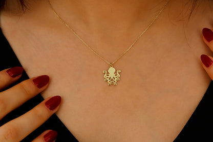 Gold necklace with an octopus pendant on a person's neck, close-up shot.