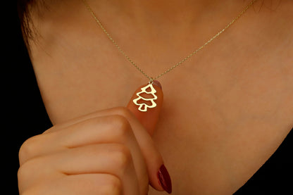 Gold necklace with a leaf pendant worn by a person