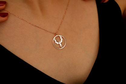 Rose gold necklace with a deer pendant on a person's neck