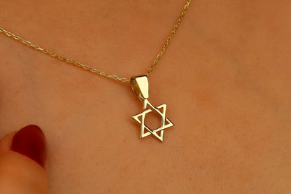 Gold necklace with a Star of David pendant on a skin background