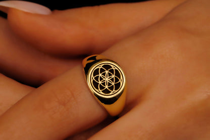 Gold ring with a black symbol on a person's finger