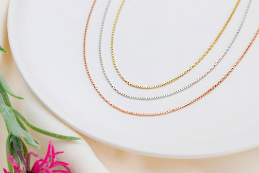 A close-up image of 3 box chains necklace in gold silver and rose, displayed on a white background.