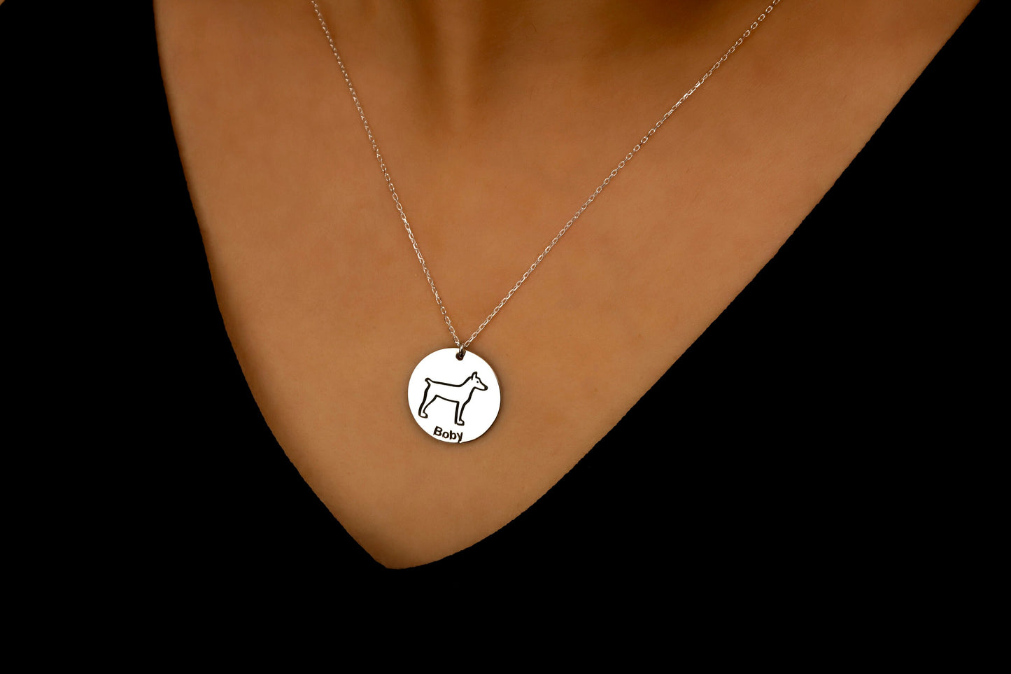 Silver necklace with a round pendant on a brown surface