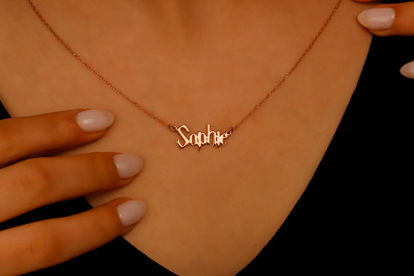 Rose gold necklace with 'Sophie' pendant on a person's neck