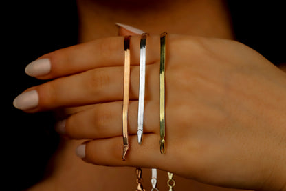 A close-up image of 3 herrighbone italian snake chains in silver gold and rose.