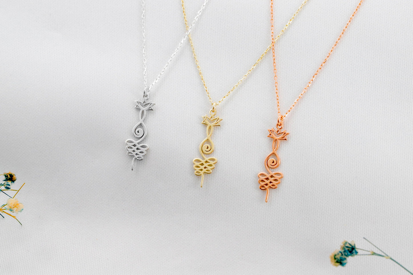 Three necklaces with unique pendants on a light gray background