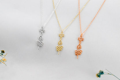 Three necklaces with unique pendants on a light gray background