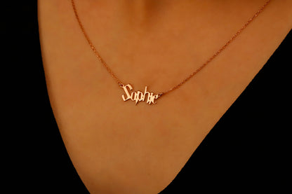 Gold necklace with 'Sophie' pendant on a person's neck against a black background