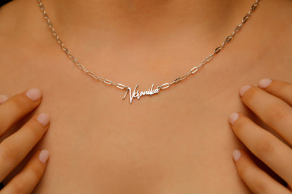 Necklace with 'Natalie' nameplate on a person's neck