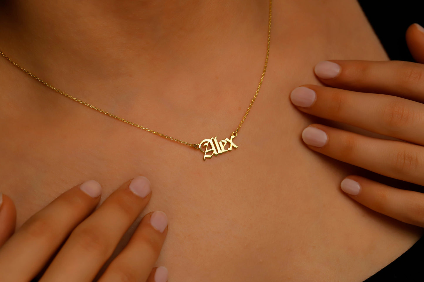 Gold necklace with 'Alex' pendant on a person's neck