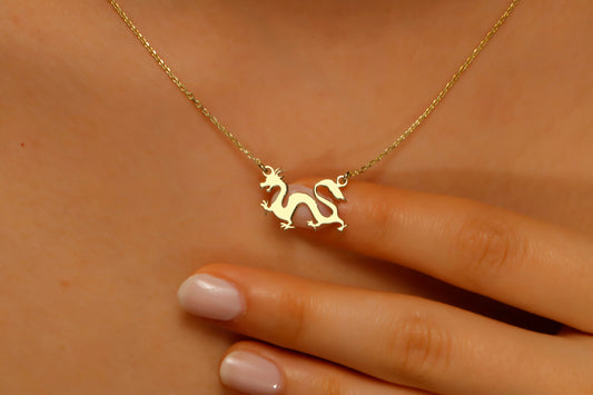 Gold necklace with a dragon pendant on a person's neck