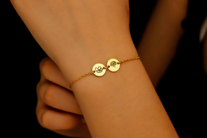 Gold bracelet with engraved discs on a wrist against a dark background