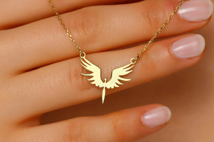 A dainty phoenix necklace with gold wings pendant on a hand, showcasing the delicate and elegant design.