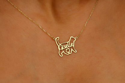 Woman wearing a gold necklace with a cat pendant.