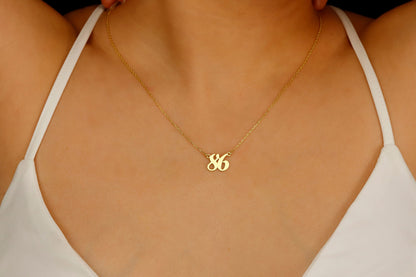 A close-up image of a woman wearing a personalized necklace with a number '86' in gold-tone on a silver chain.