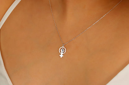 A silver necklace with a Venus symbol pendant on a model
