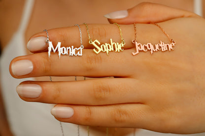 A close-up image of a woman's hand displaying 3 dainty necklaces in  gold, silver and rose with the name 'Sophie' 'Monica'  'Jacqueline'  written in a magical Harry P. font.
