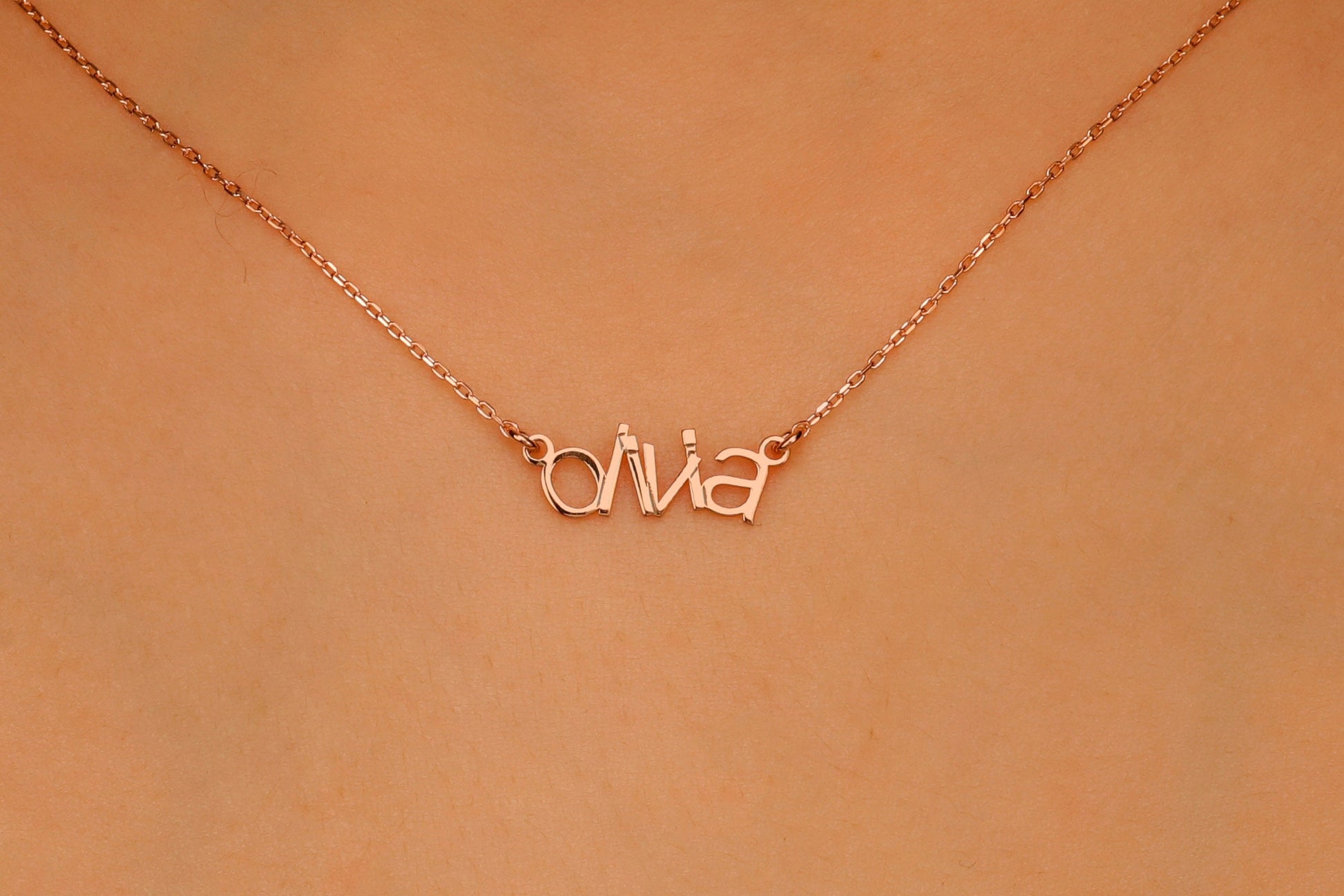 Rose gold 'Olivia' necklace on a peach background