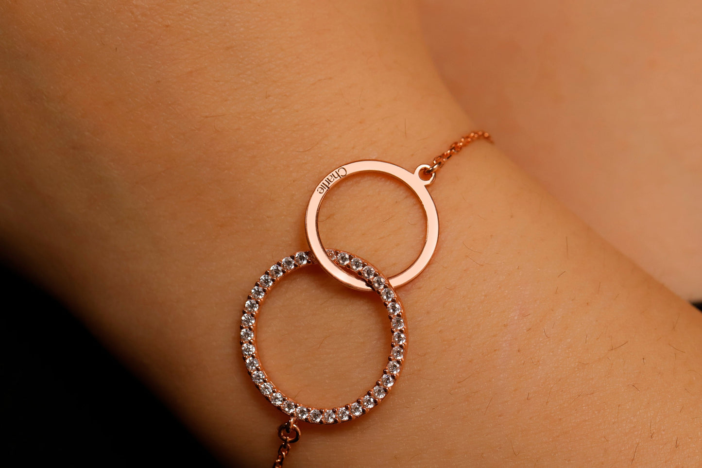Rose gold bracelet with interlocking rings on a person's wrist