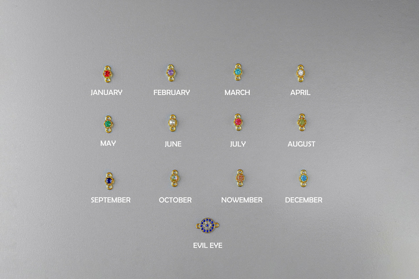 Set of earrings with gemstones for each month on a gray background